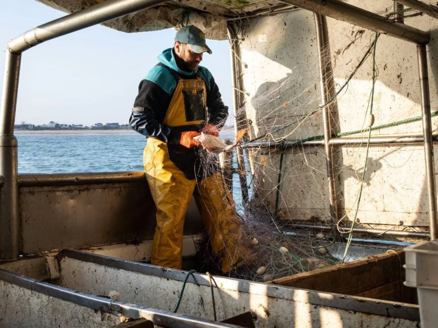 Pecheur en mer sur son bateau et son filet