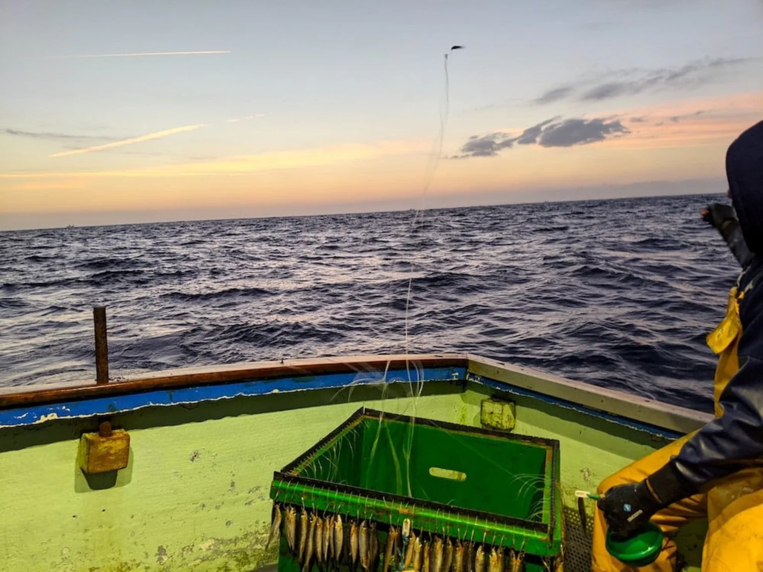 Pêcheur en mer avec couché de soleil.