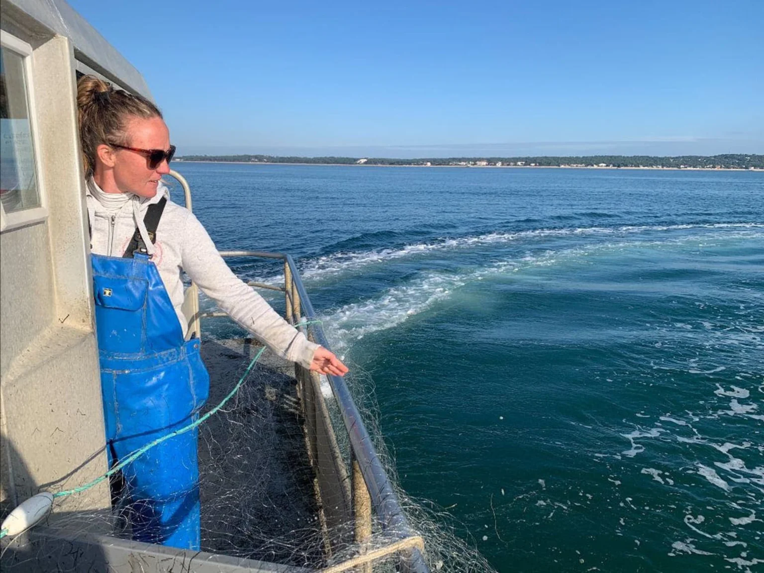 Pêcheuse Poiscaille à bord de son bateau au soleil