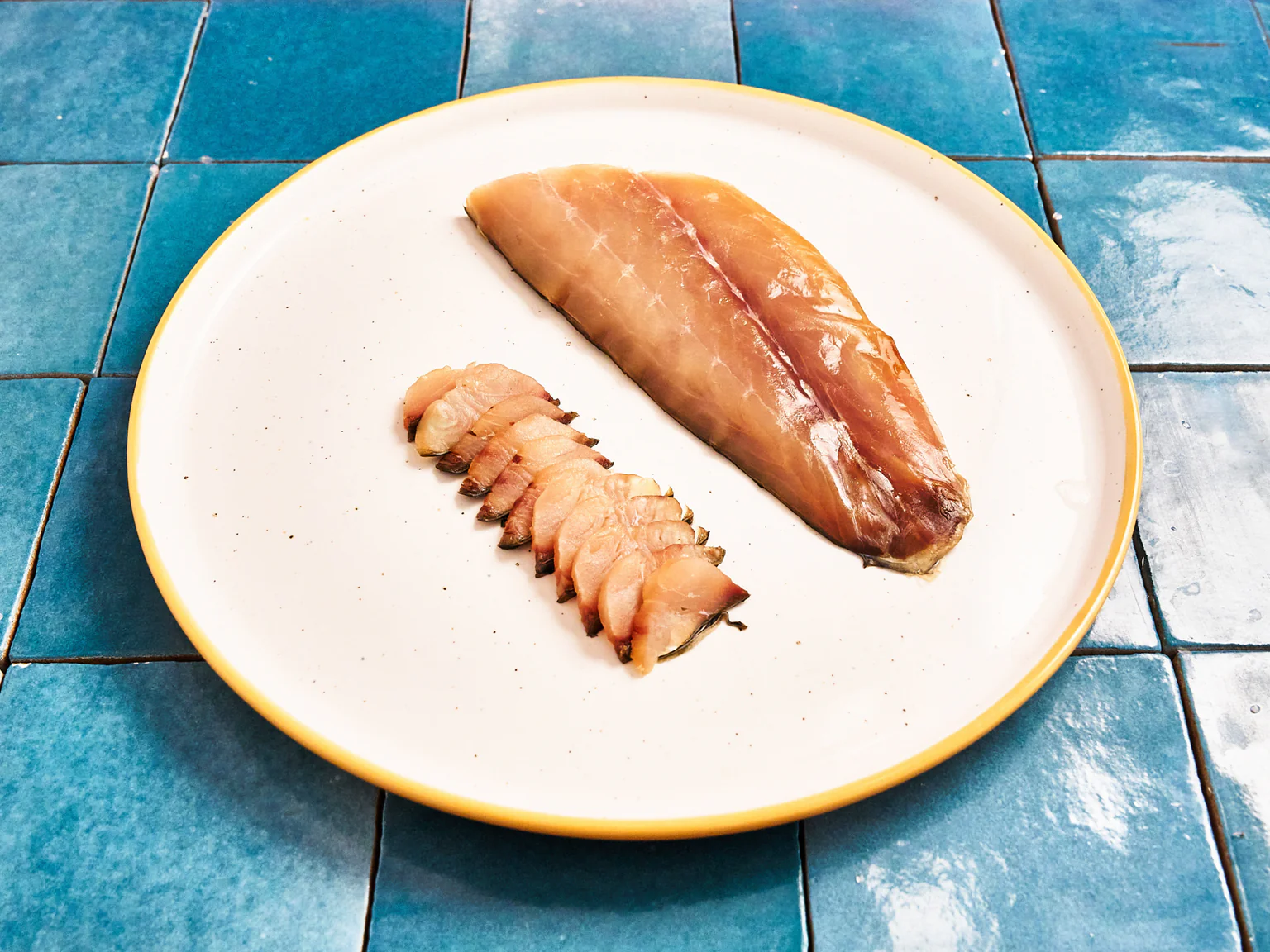 Photo d'un filet de mulet fumé carrelage bleu
