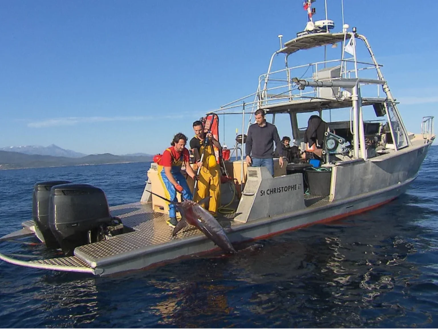 Un pêcheur qui remonte un espadon sur son bateau